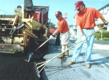 Photo: Jim Maza and Mario Mele spread blacktop (The Record, Doylestown, PA)